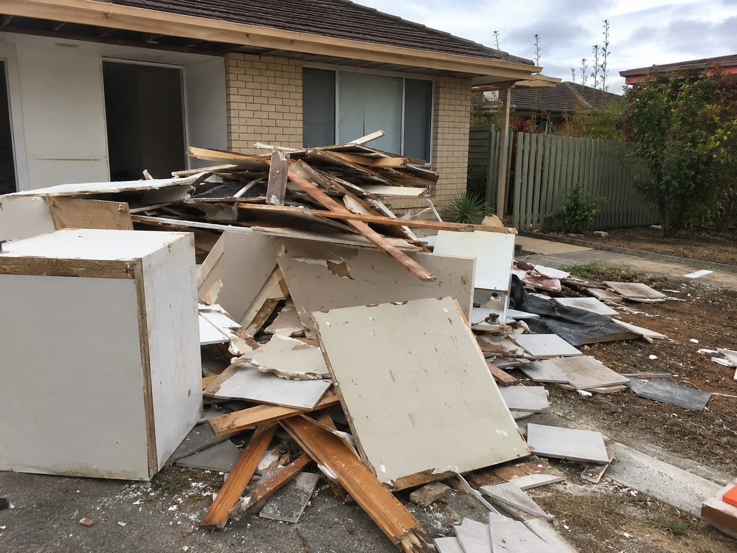 Renovation debris of plasterboard, timber and tiles piled outside a Gold Coast house