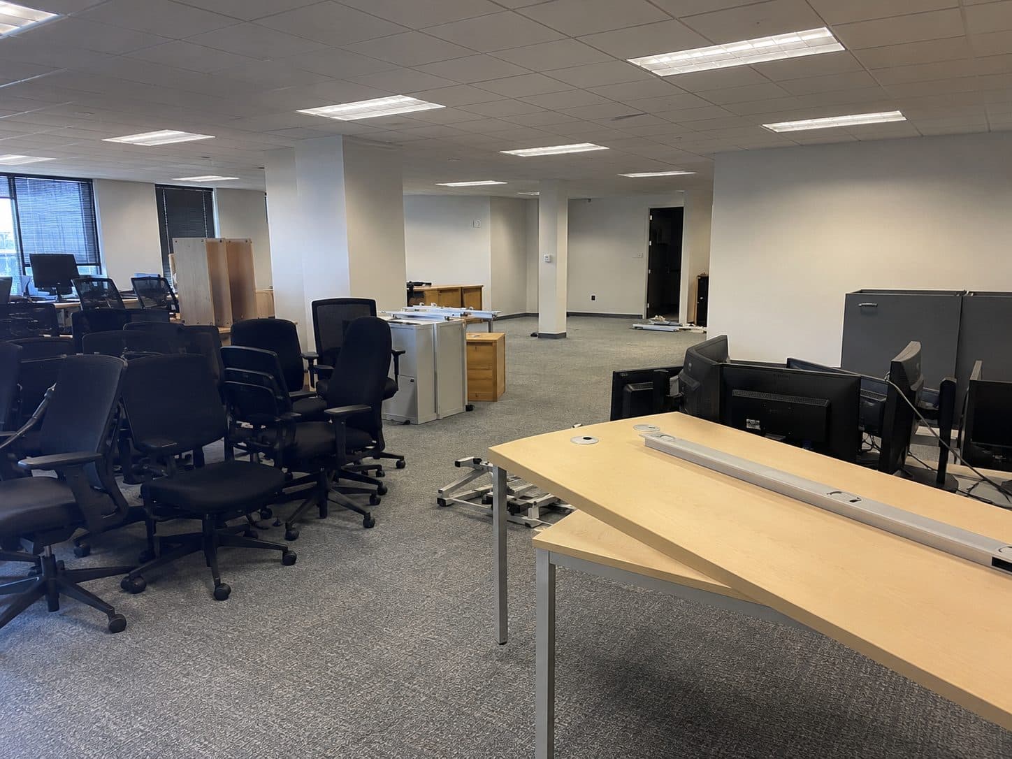 Gold Coast office being cleared with stacked chairs, desks and monitors