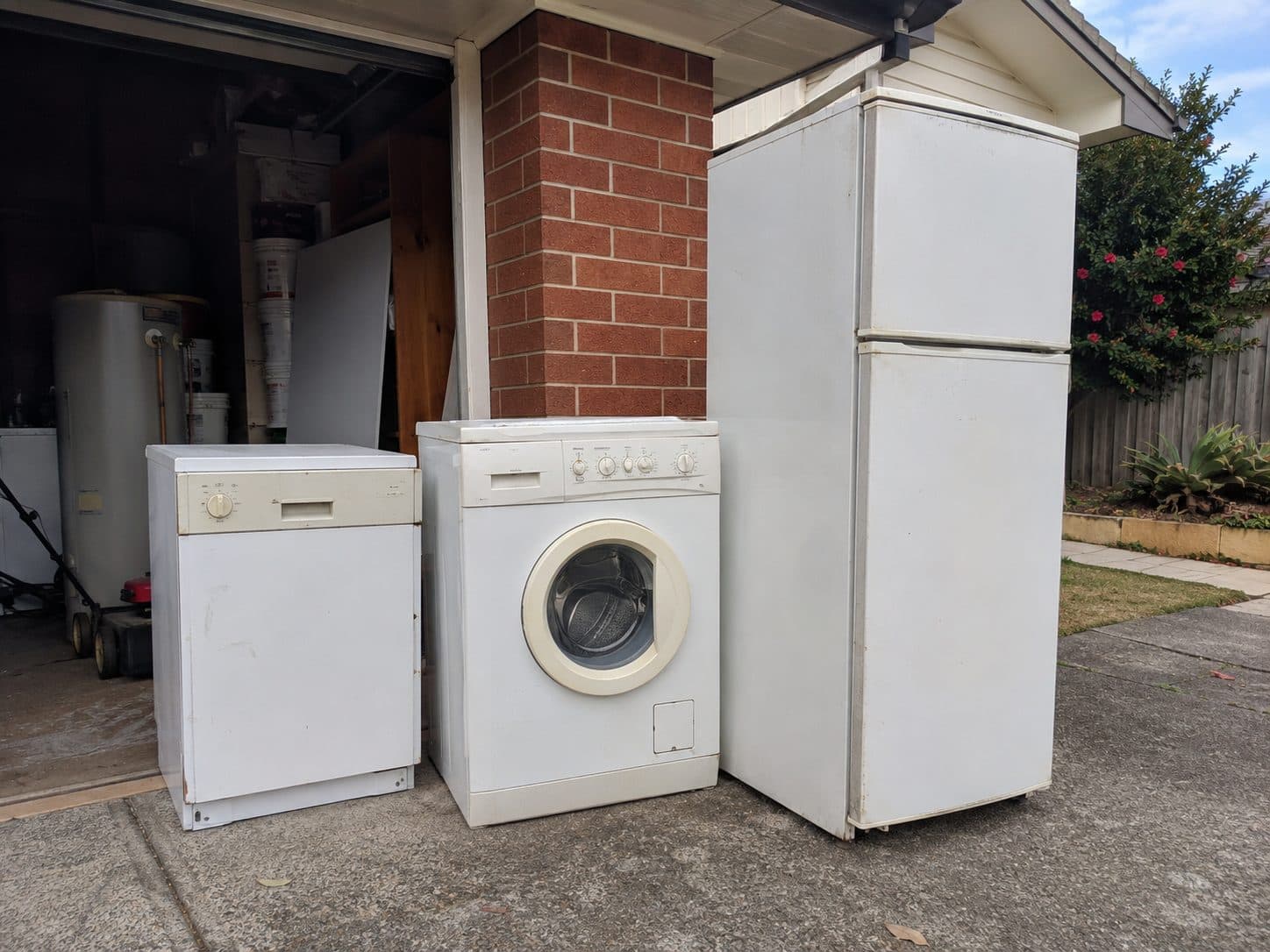 Old fridge, washing machine and dishwasher on a Gold Coast driveway for appliance removal